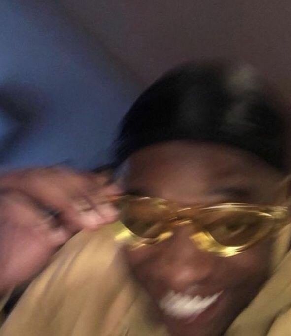 Person smiling in gold-tinted sunglasses
